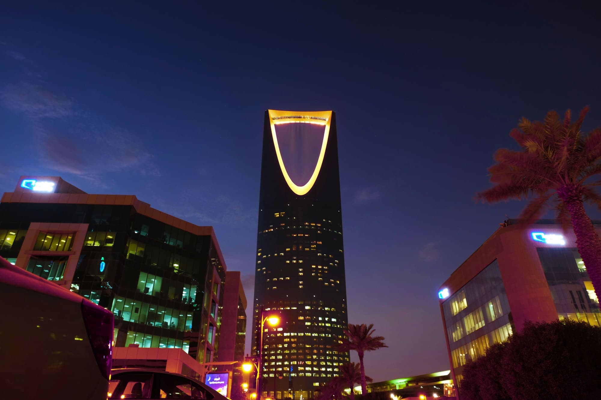 O Kingdom Centre, em Riade, iluminado ao anoitecer, com a abertura em arco no alto da torre.