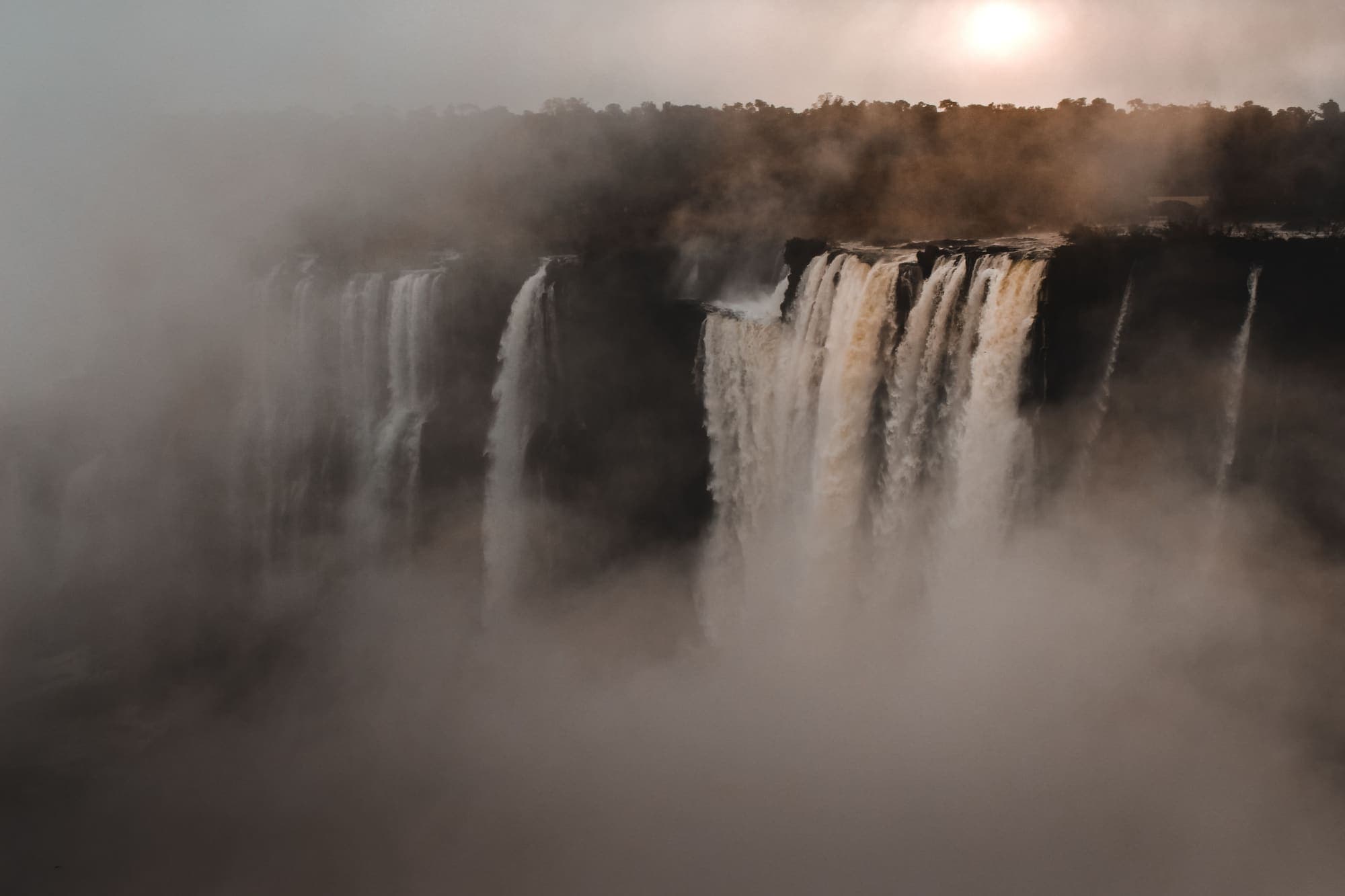 As quedas das Cataratas Victoria encobertas pela névoa que sobe do desfiladeiro.