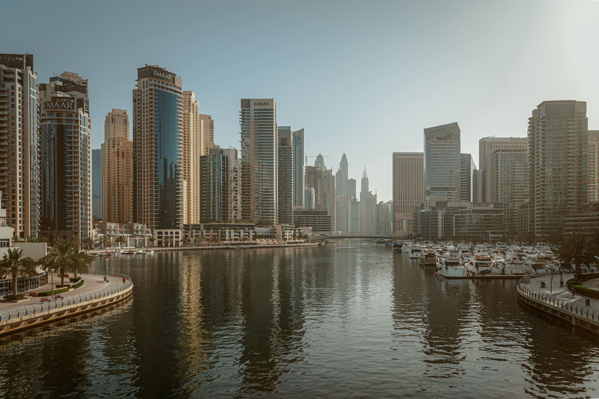 O canal da Dubai Marina entre torres residenciais, com iates atracados ao fundo.