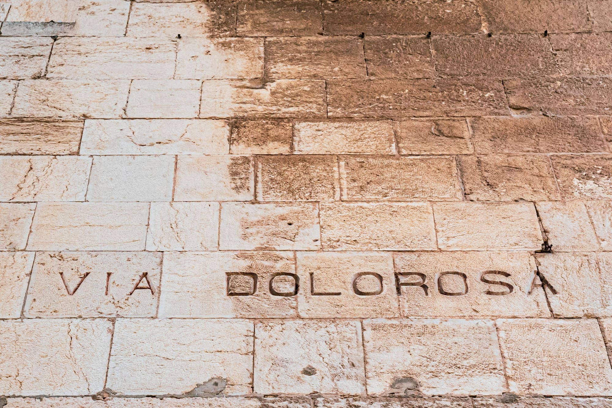 O nome Via Dolorosa gravado num muro de pedra clara em Jerusalém.