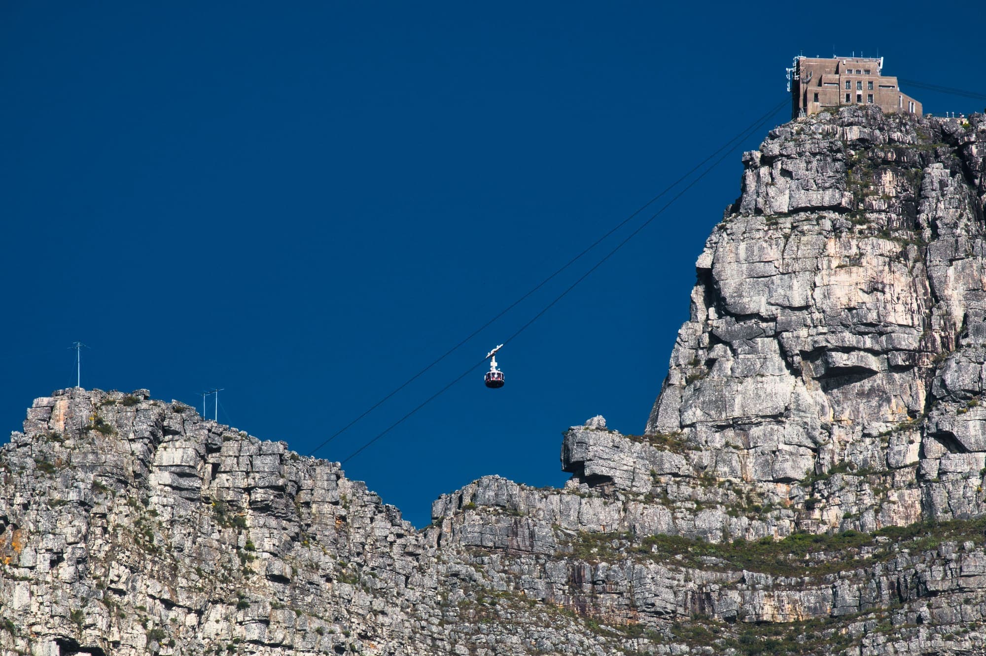 Uma cabine do teleférico subindo os paredões de pedra da Table Mountain até a estação no alto.
