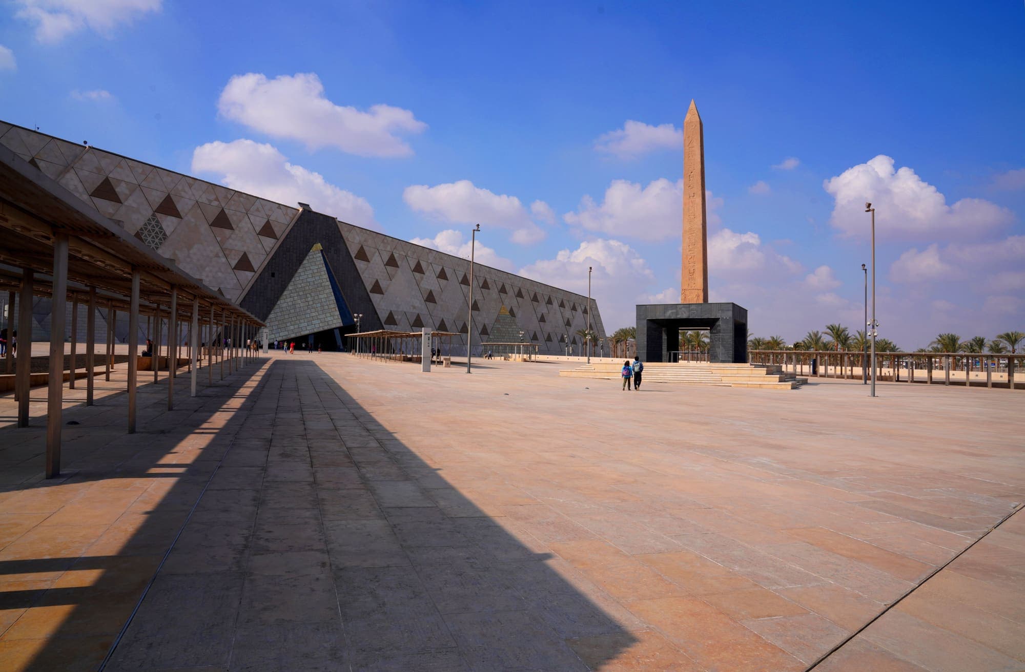 A fachada do Grande Museu Egípcio, perto de Gizé, com o obelisco na praça de entrada.