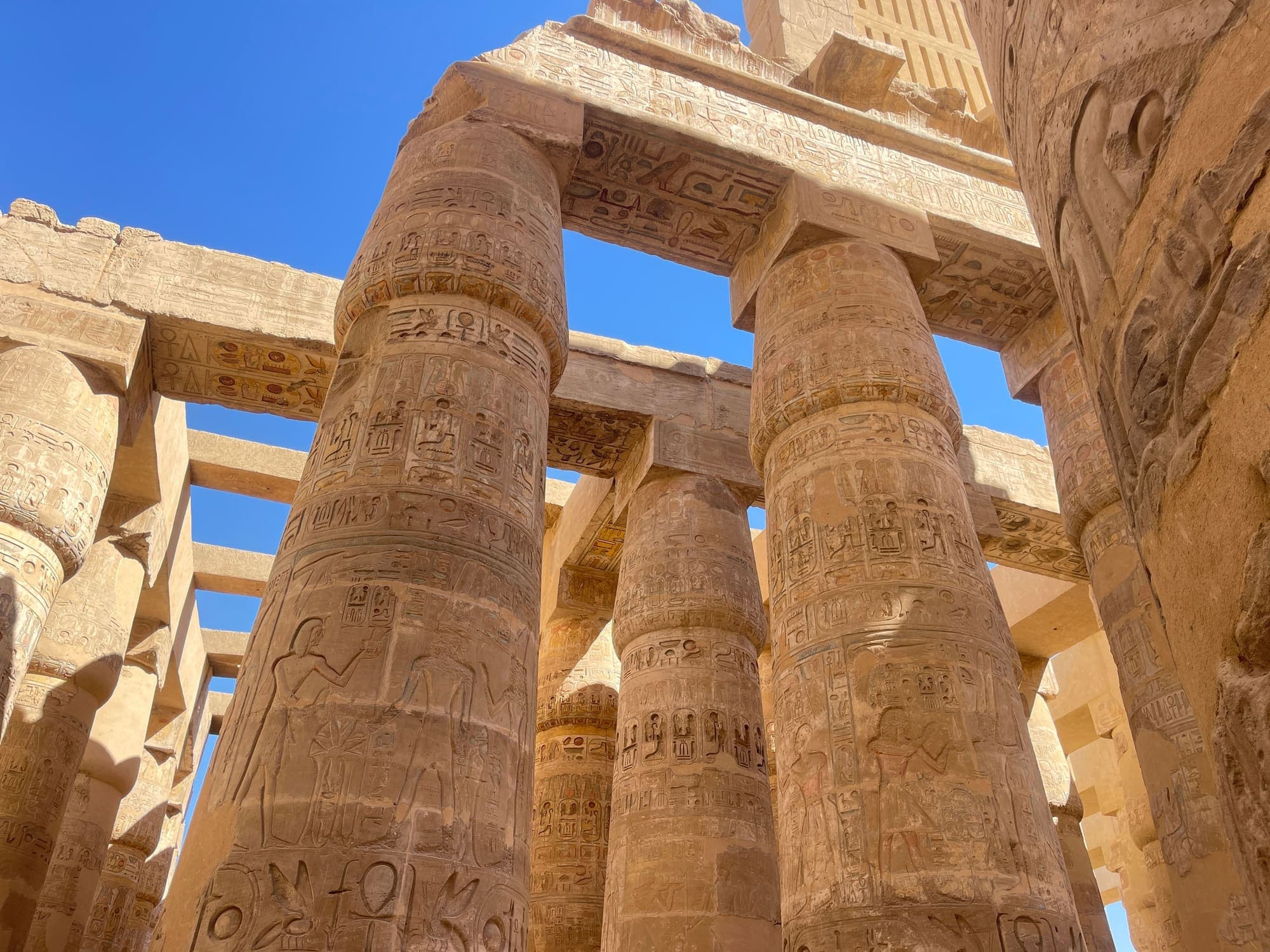 Colunas cobertas de hieróglifos no Templo de Karnak, em Luxor, vistas de baixo.