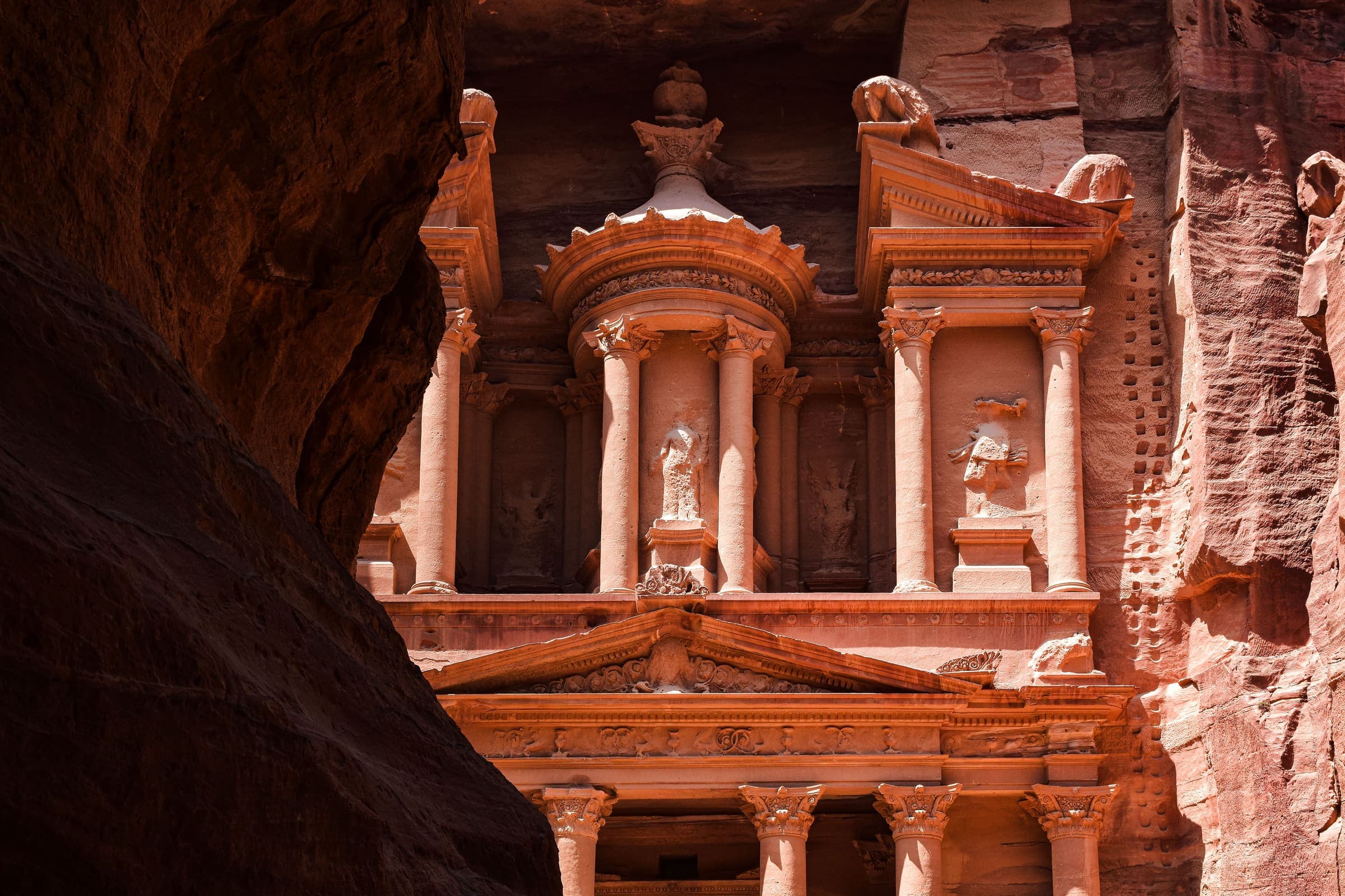 A fachada do Tesouro, em Petra, esculpida no arenito rosado, vista do fim do Siq.