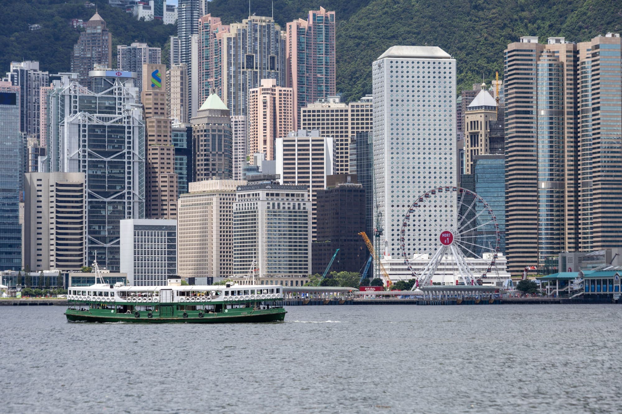 Uma balsa da Star Ferry atravessando o porto Victoria diante dos arranha-céus da ilha de Hong Kong.