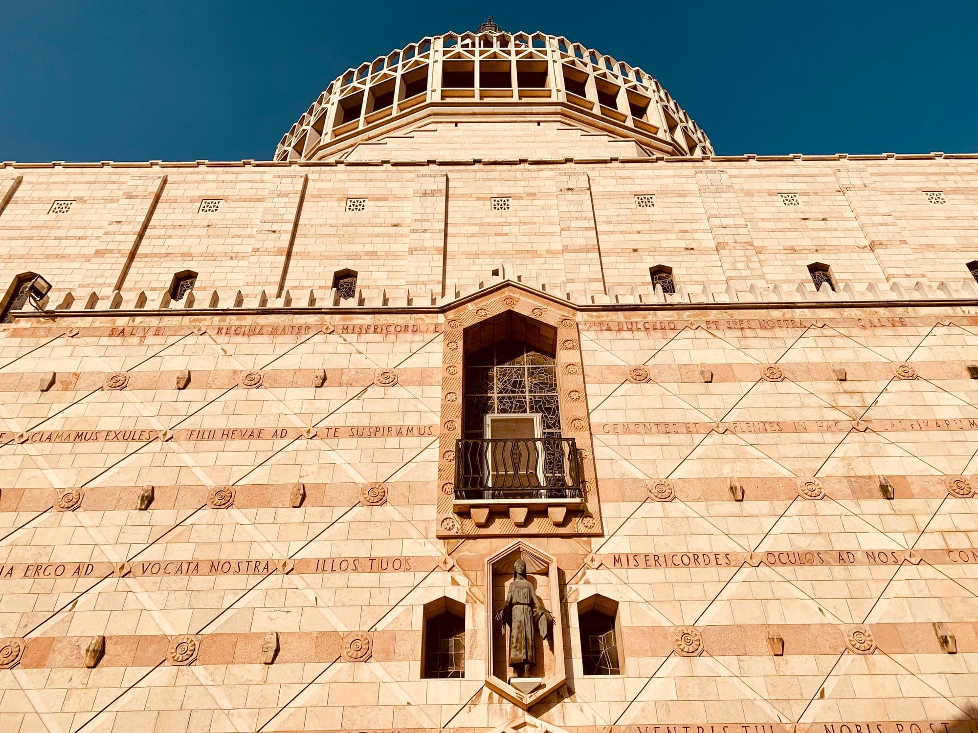 A fachada da Basílica da Anunciação, em Nazaré, de pedra em faixas, com a cúpula no alto.