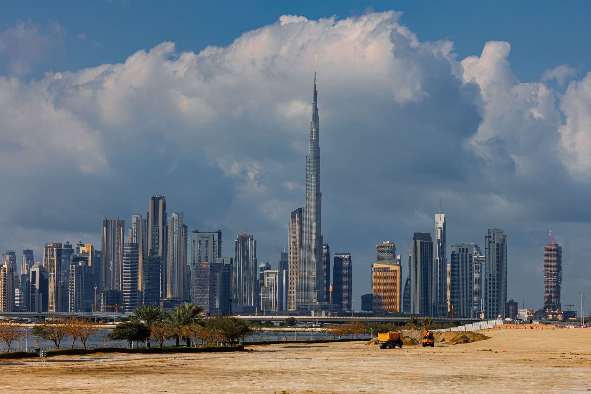 O Burj Khalifa erguendo-se entre os arranha-céus do centro de Dubai, sob grandes nuvens.