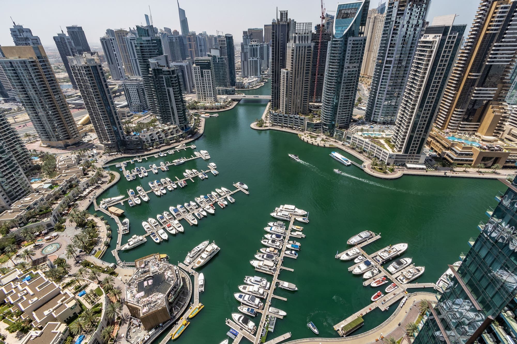 Vista aérea da Dubai Marina, com iates atracados no canal entre os arranha-céus.