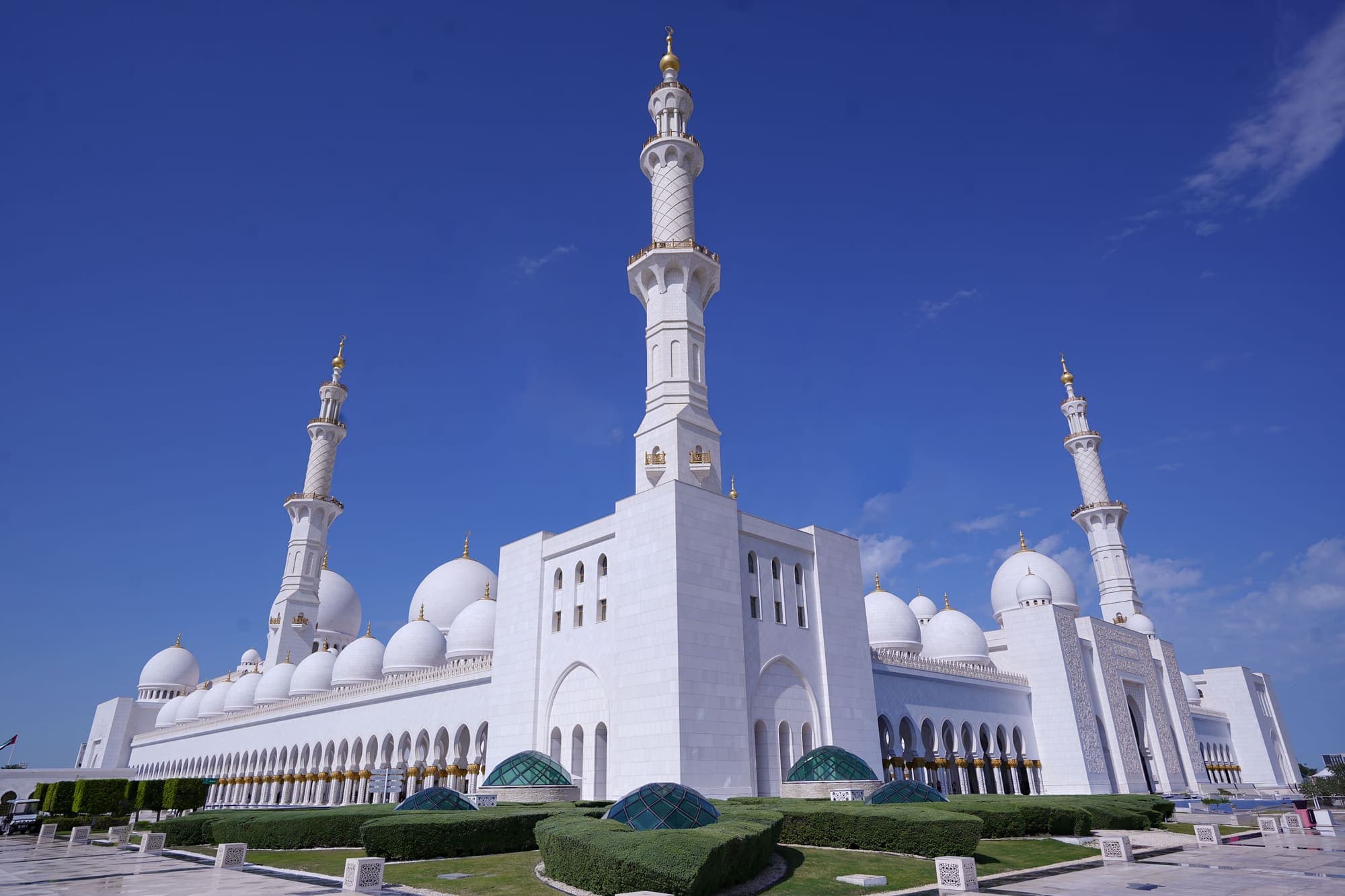 A Grande Mesquita Sheikh Zayed, em Abu Dhabi, com suas cúpulas brancas e minaretes sob o céu azul.