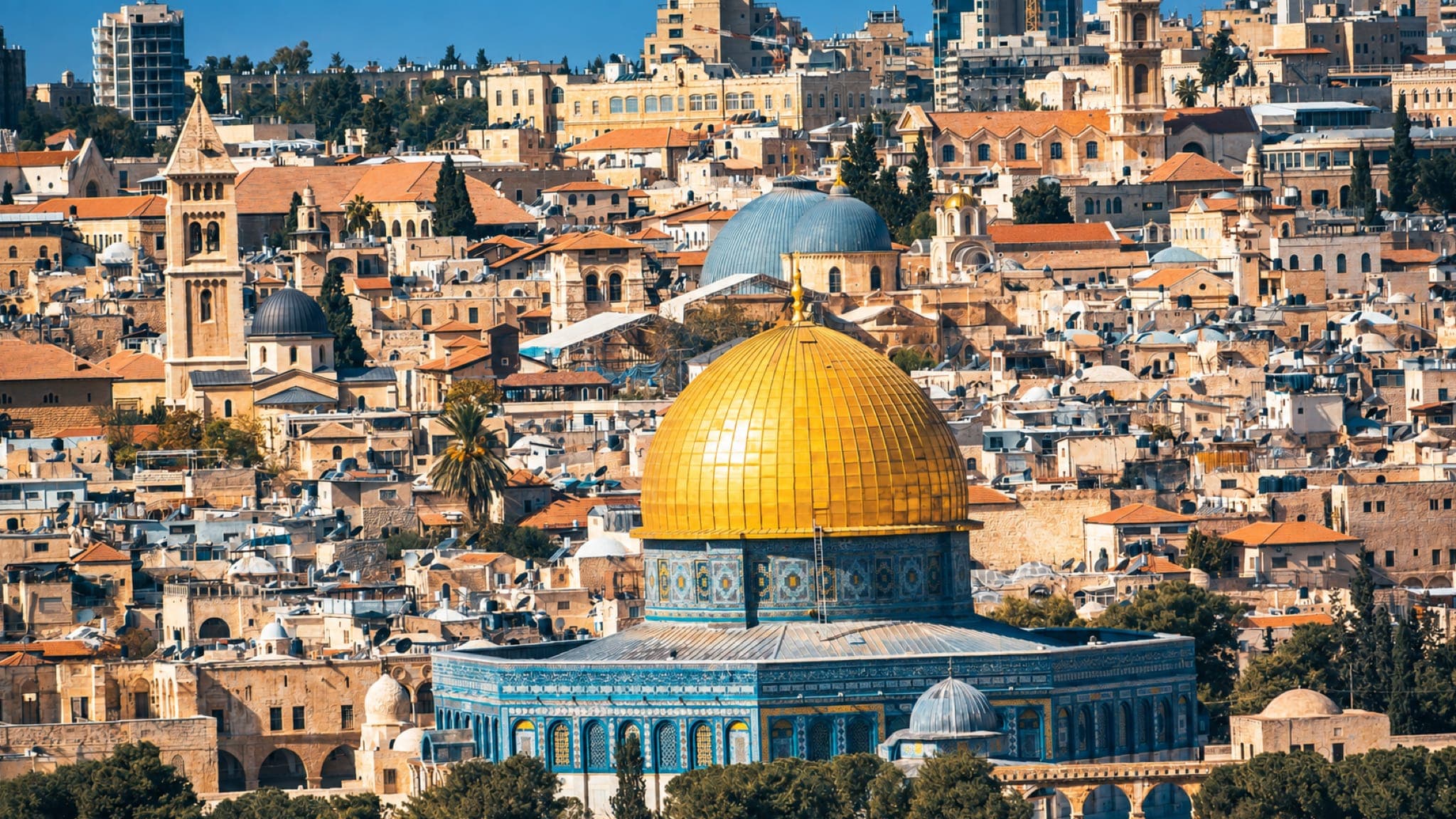 A Cúpula da Rocha, com sua cúpula dourada, diante dos telhados, cúpulas e campanários da Cidade Velha de Jerusalém.