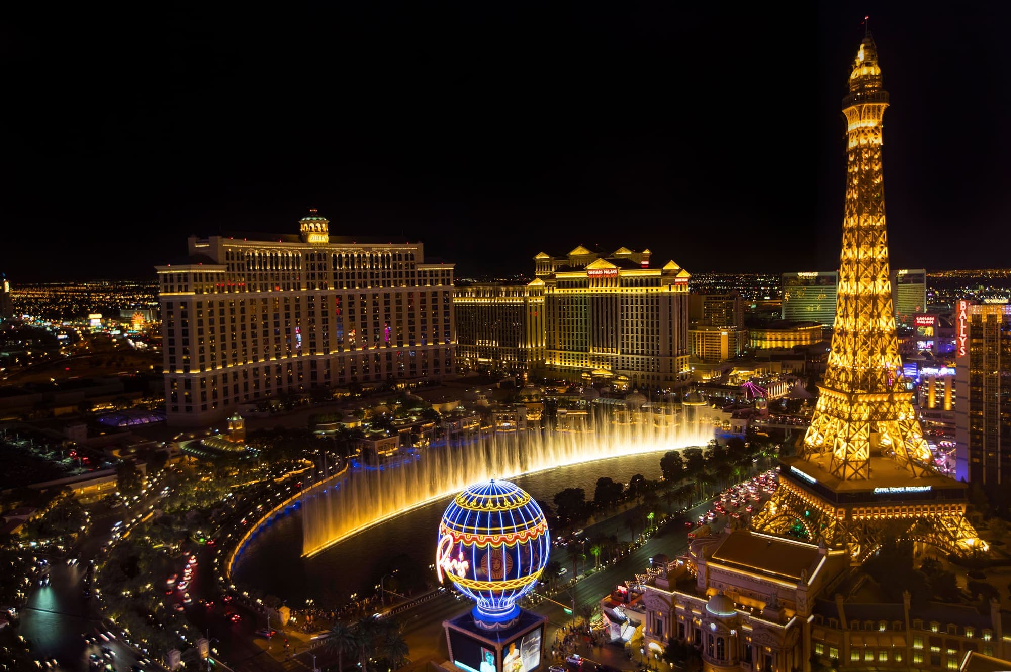 A Strip de Las Vegas à noite, com as fontes do Bellagio e a réplica da Torre Eiffel do hotel Paris iluminadas.