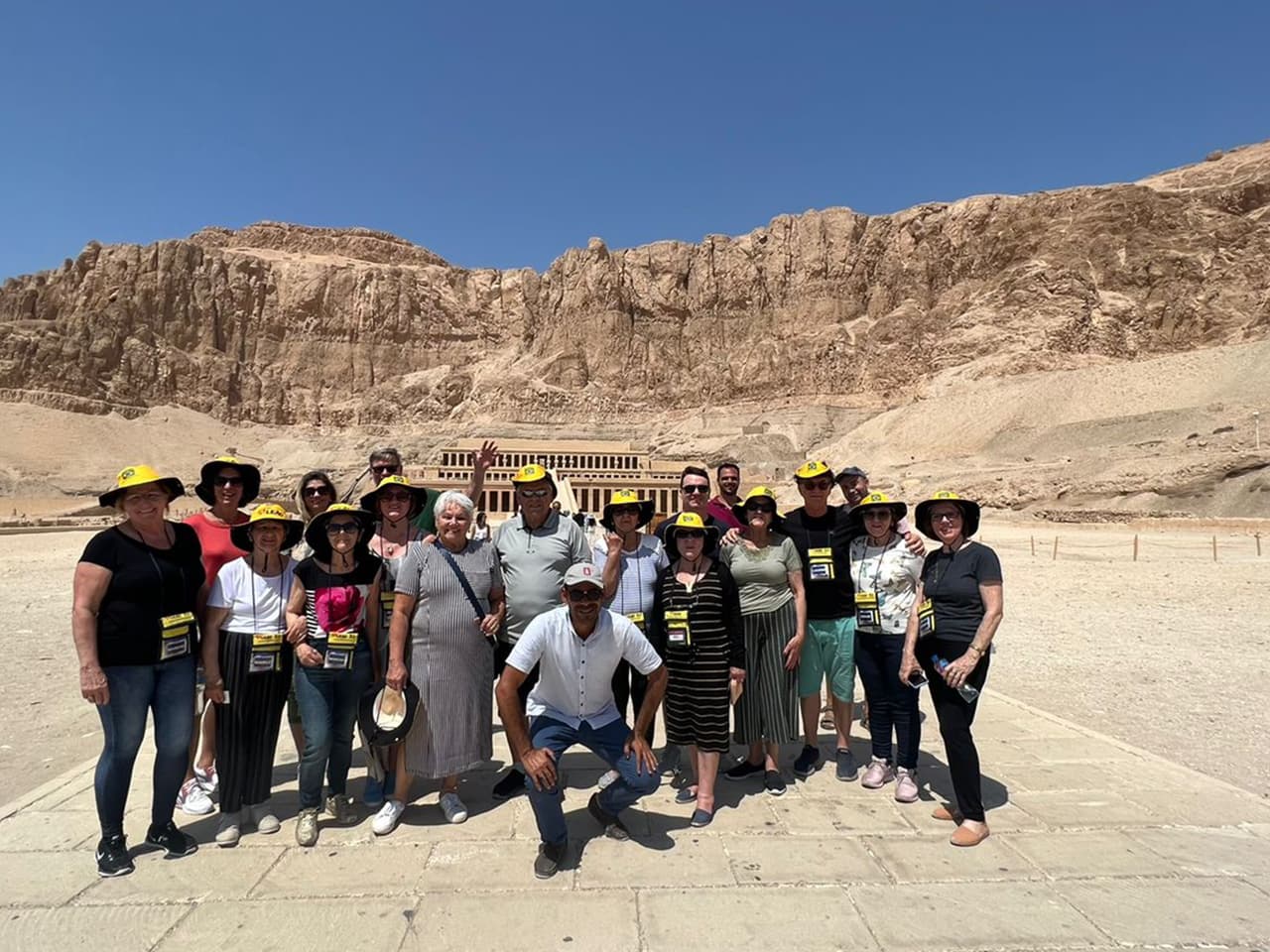 Grupo da Leão Viagens com chapéus amarelos diante do templo de Hatshepsut, em Luxor.